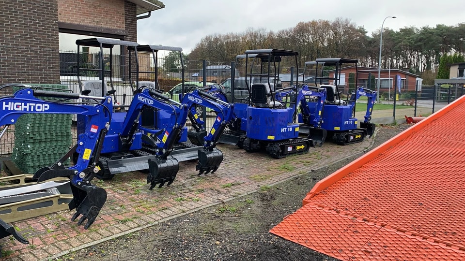 Plusieurs mini-pelles HT-10BZ alignées dans la cour d’un concessionnaire belge