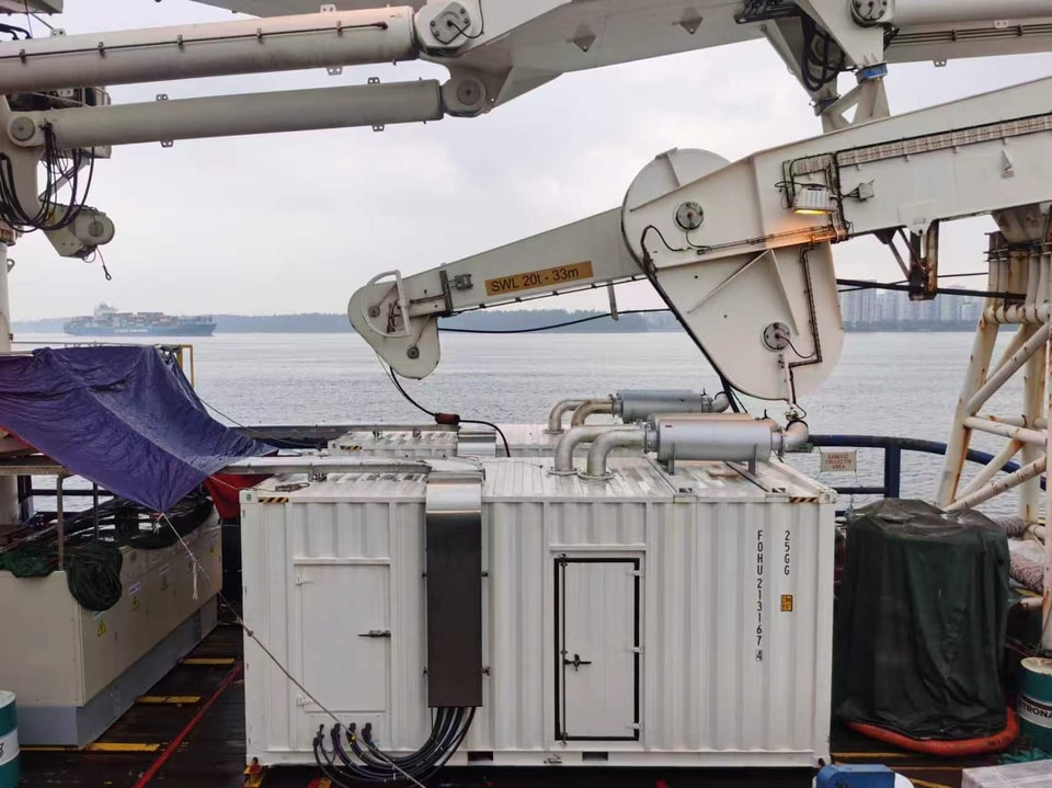 Weather-protected containerized generator on a vessel deck