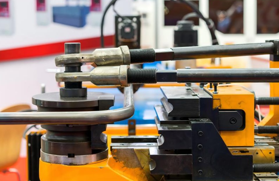 How can safety be ensured when bending pipes during the manufacturing of amusement rides?